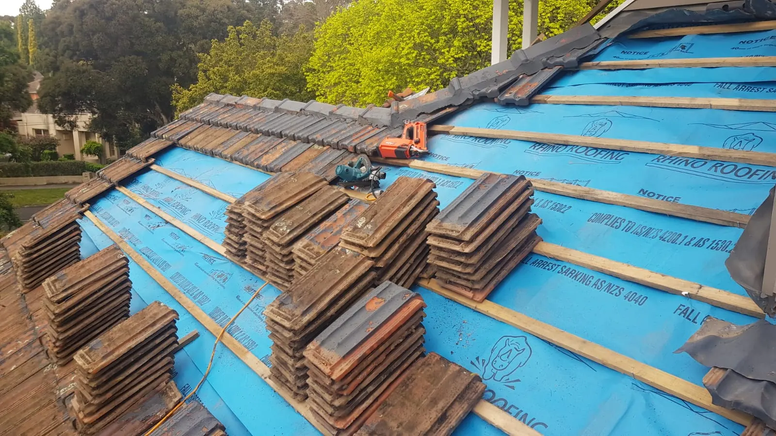 Tiled roof restoration with underlay and battens exposed during tile relaying