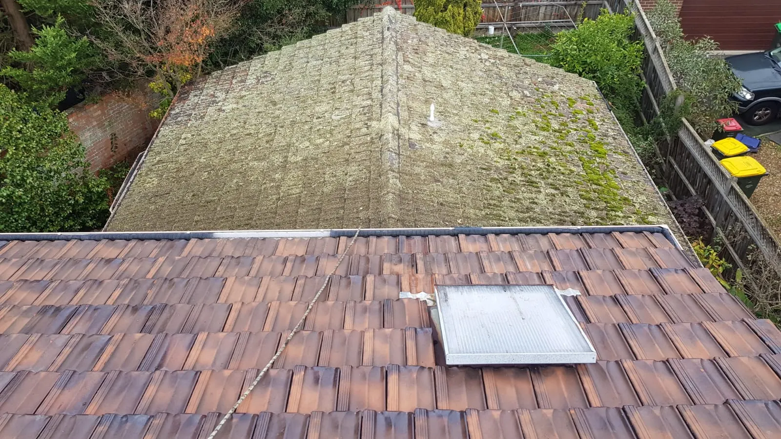 Tiled roof areas showing weathering, moss growth and renewed tiles